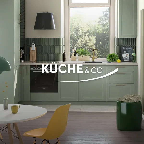 Grüne Küche mit Esstisch und gelben Stühlen unter einer grünen Hängelampe. Ein grüner Hocker steht neben einer weißen Tür.