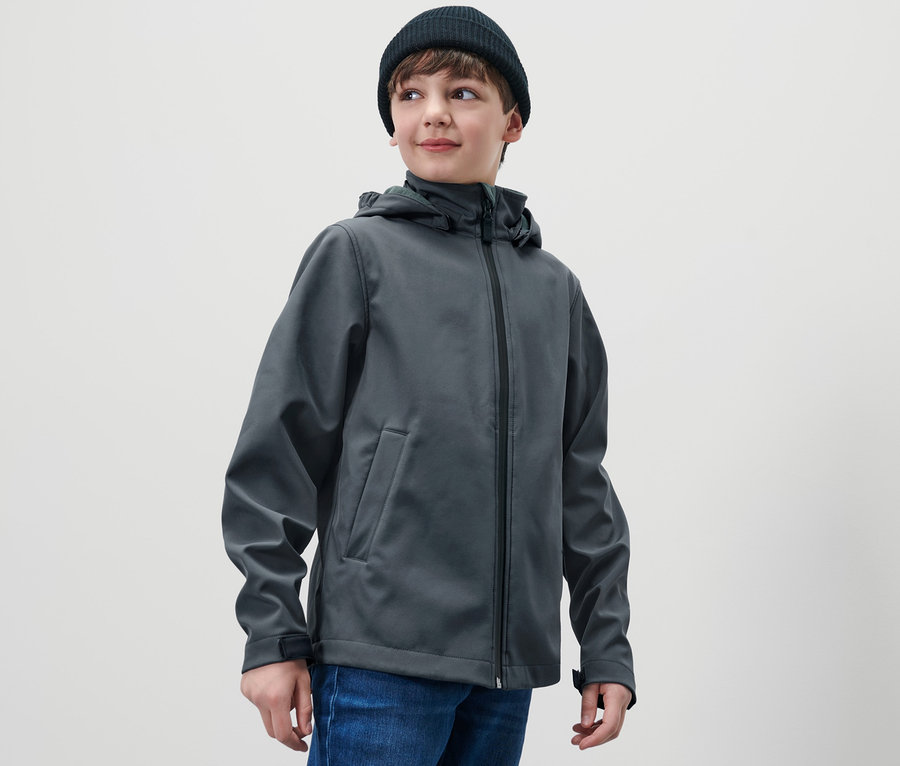 Junge mit schwarzer Mütze und Kinder-Softshelljacke.