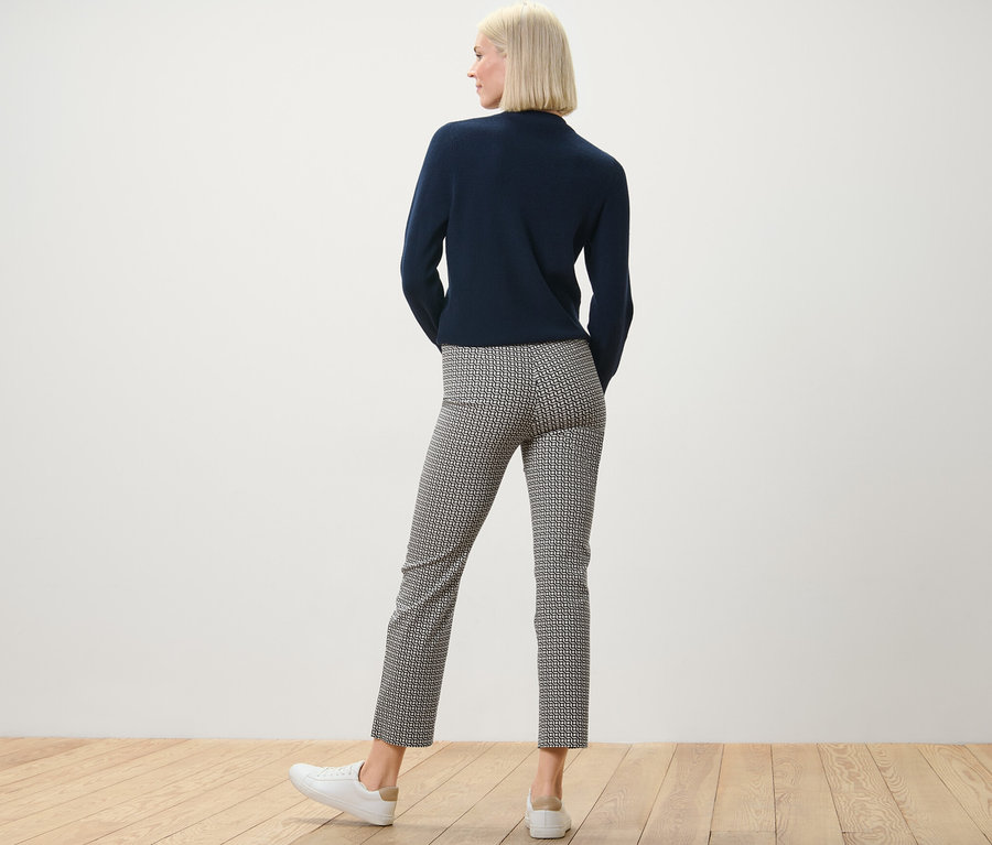 Frau von hinten in marineblauem Oberteil und bedruckter Stretchhose, navy.