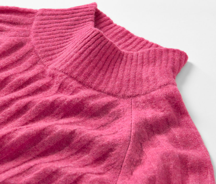 Detailaufnahme eines gerippten Strickpullovers mit Stehkragen.