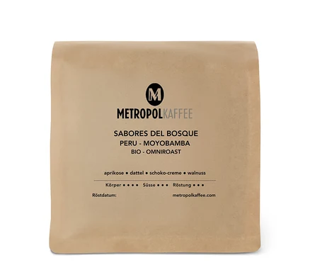 Helle braune Kaffeepackung von METROPOLKAFFEE mit der Aufschrift 'METROPOL Peru Bio Omni-Roast Ganze Bohne', 'Sabores del Bosque' und Geschmacksnoten wie Aprikose, Dattel, Schoko-Creme, Walnuss.
