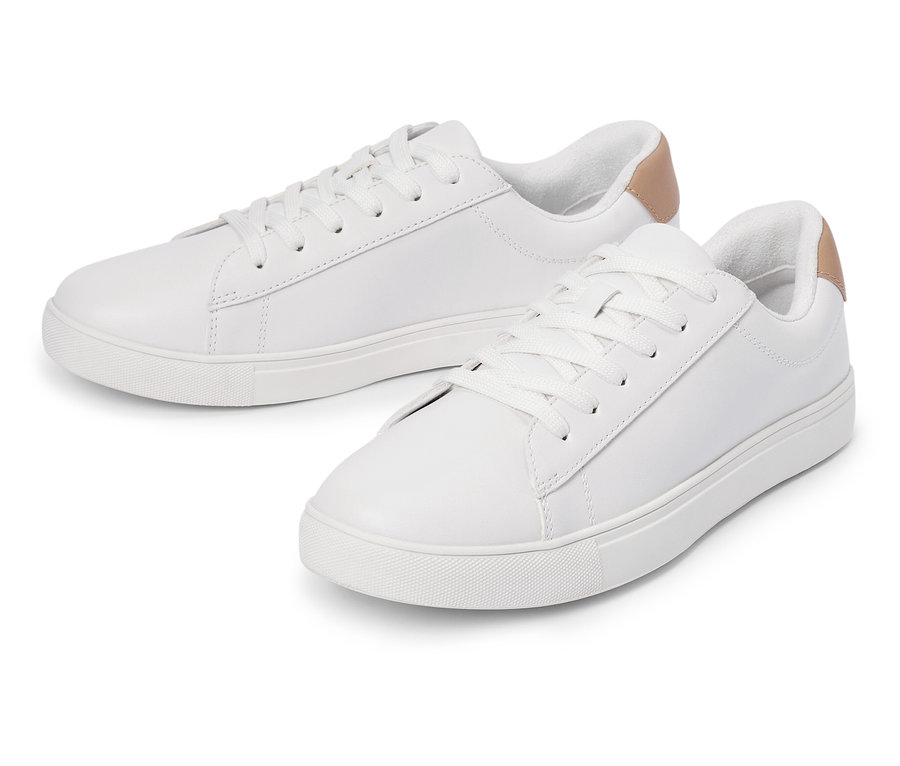 Zwei weiße Turnschuhe mit Schnürsenkeln und hellbraunem Detail an der Ferse liegen nebeneinander.