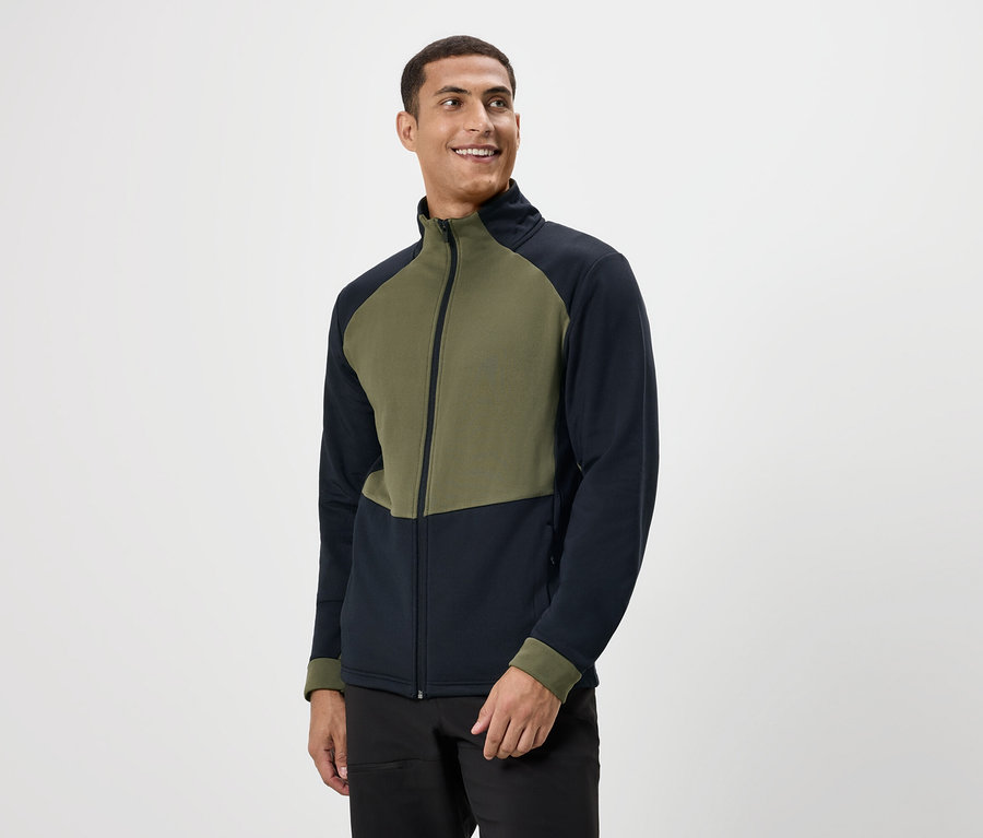 Mann lächelt und trägt eine olivgrüne und marineblaue Reißverschlussjacke.