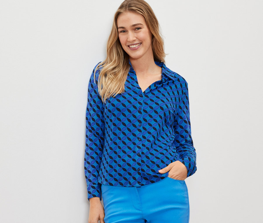 Frau trägt ein blaues Blusenshirt mit Knopfleiste.