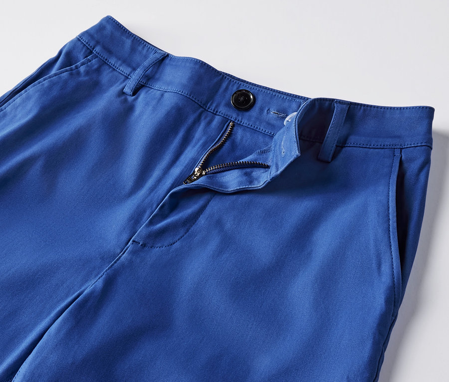Detailansicht einer kobaltblauen Chino mit offenem Reißverschluss.