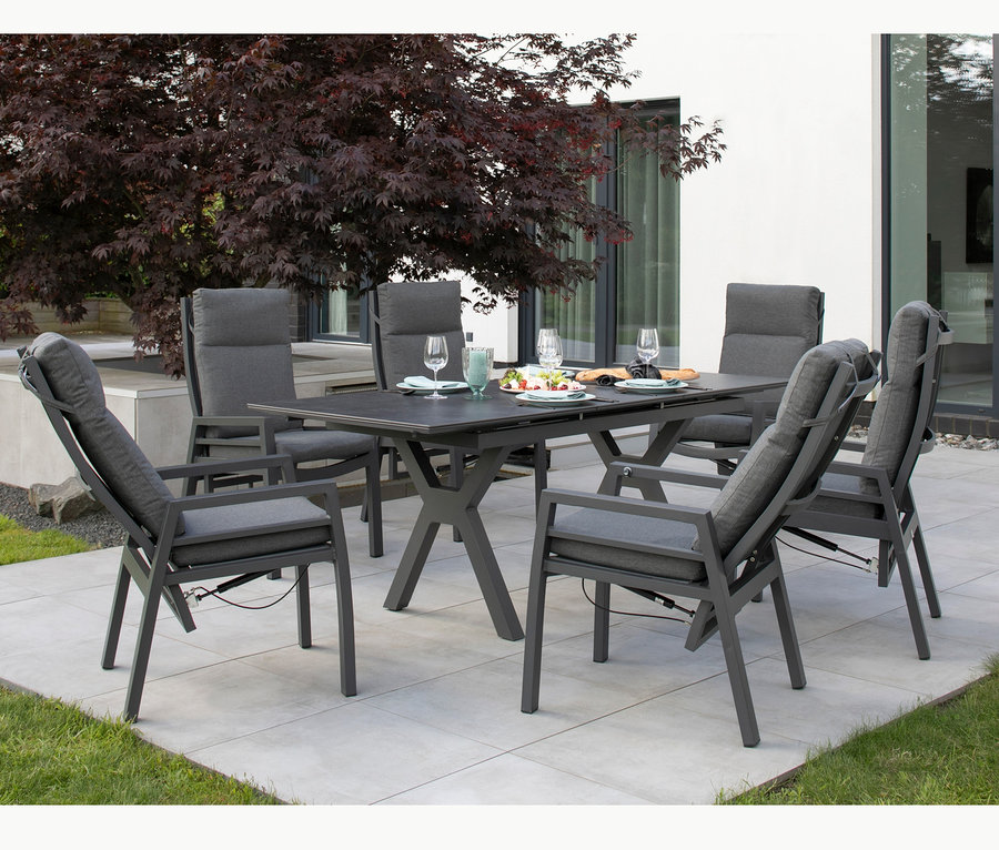 Sechs graue deVries Montana Alu-Dining-Sessel stehen im Freien um einen rechteckigen Esstisch.