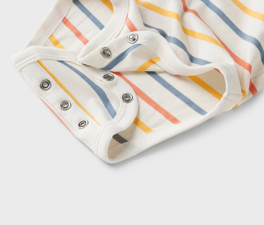 Nahaufnahme eines weißen Babybodys mit bunten Streifen und Druckknöpfen.